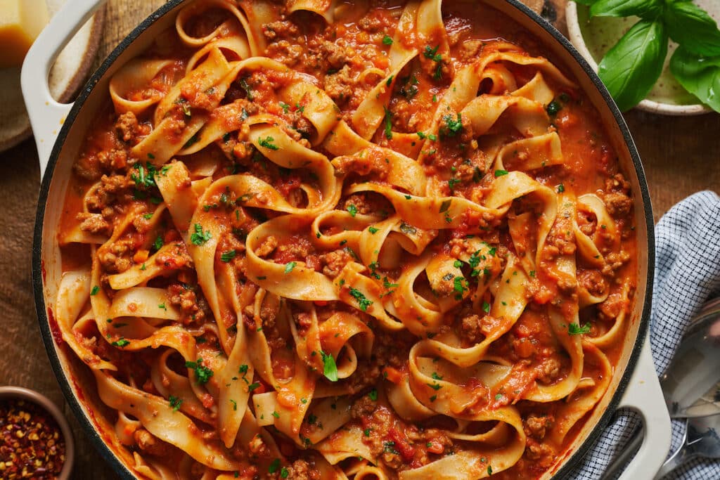 A bowl of pasta topped with my bolognese sauce and fresh basil.