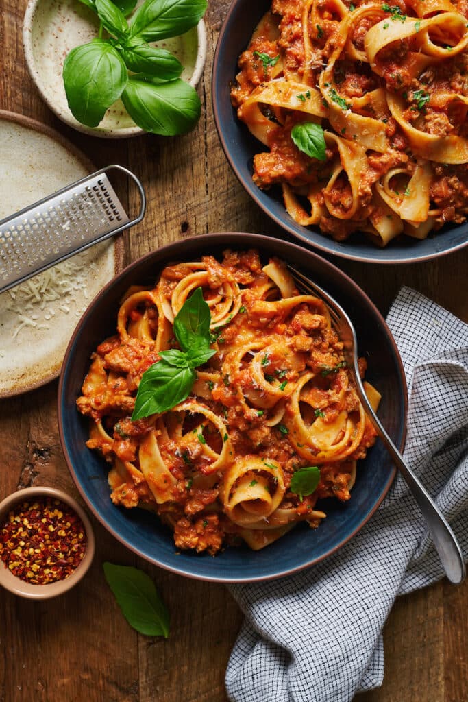 A bowl of pasta topped with my bolognese sauce and fresh basil.