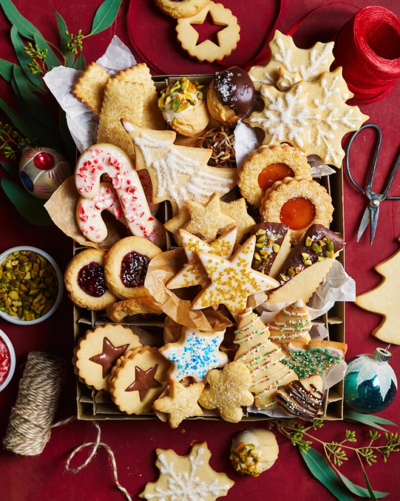 Cookie box full of decorated Christmas cookies. 