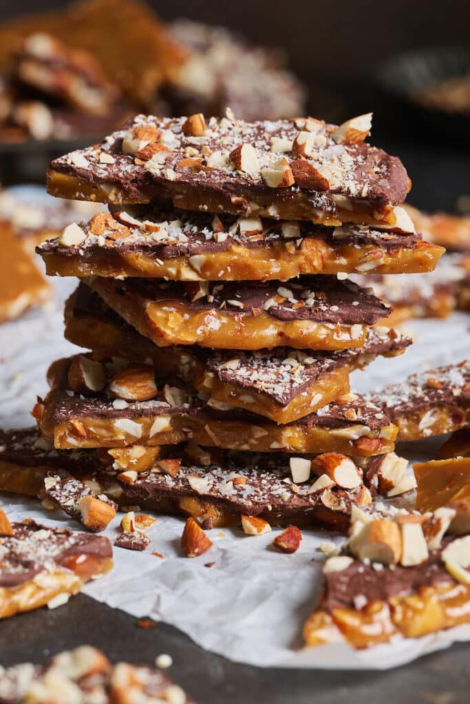 Stack of homemade toffee on parchment paper. 