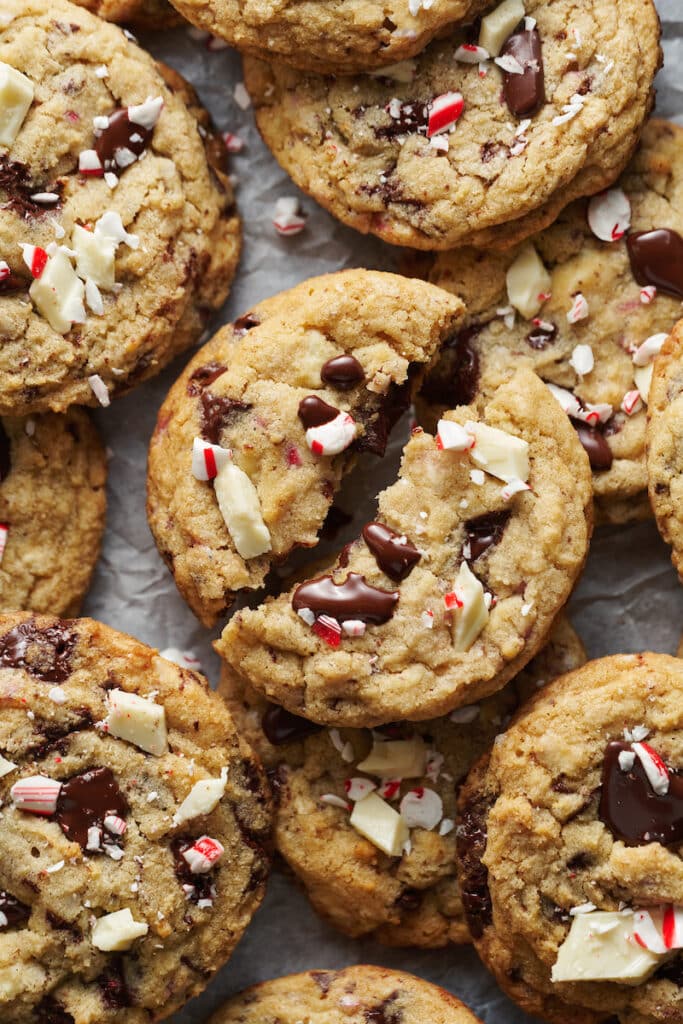 Candy cane cookies stacked with one broken in half.