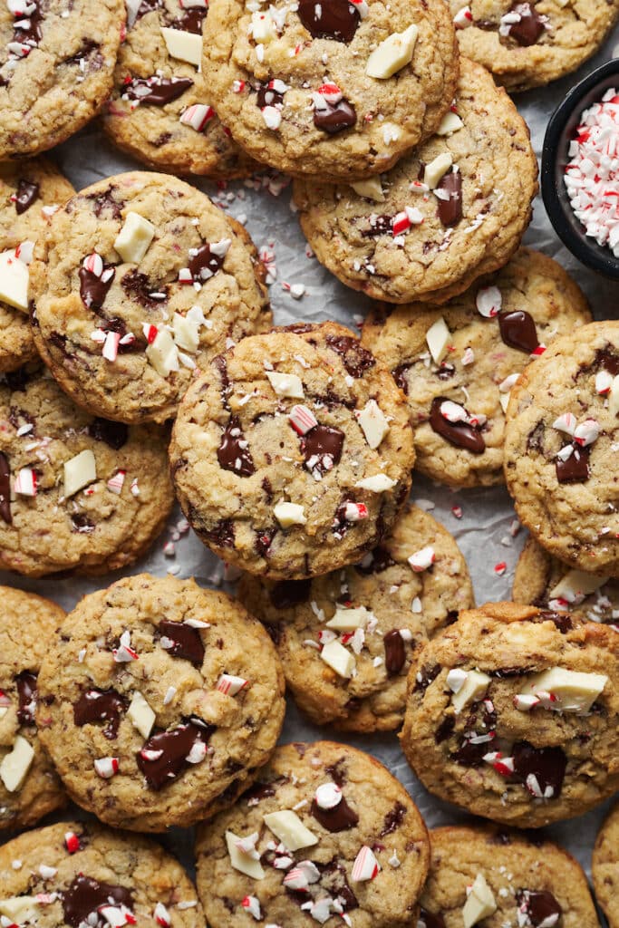 A tray of chocolate chip candy cane cookies with extra chocolate chunks on top.