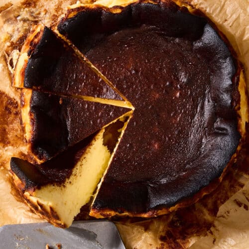 Basque cheesecake sliced on parchment paper.