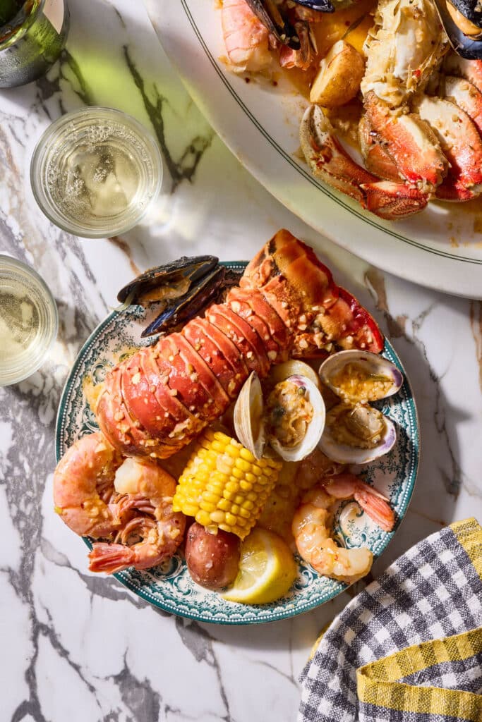 Seafood boil with corn on the cob, red potatoes, lobster, shrimp, and crab.