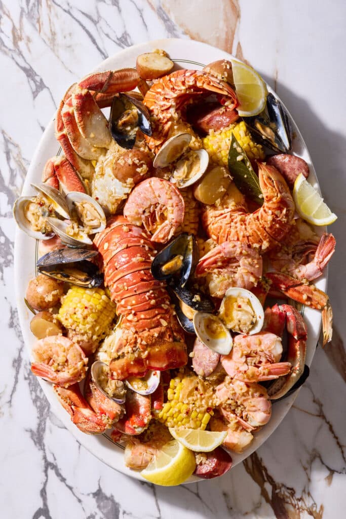 Seafood boil with corn on the cob, red potatoes, lobster, shrimp, and crab.