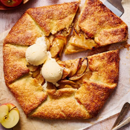 Apple galette with vanilla ice cream on top of parchment paper.