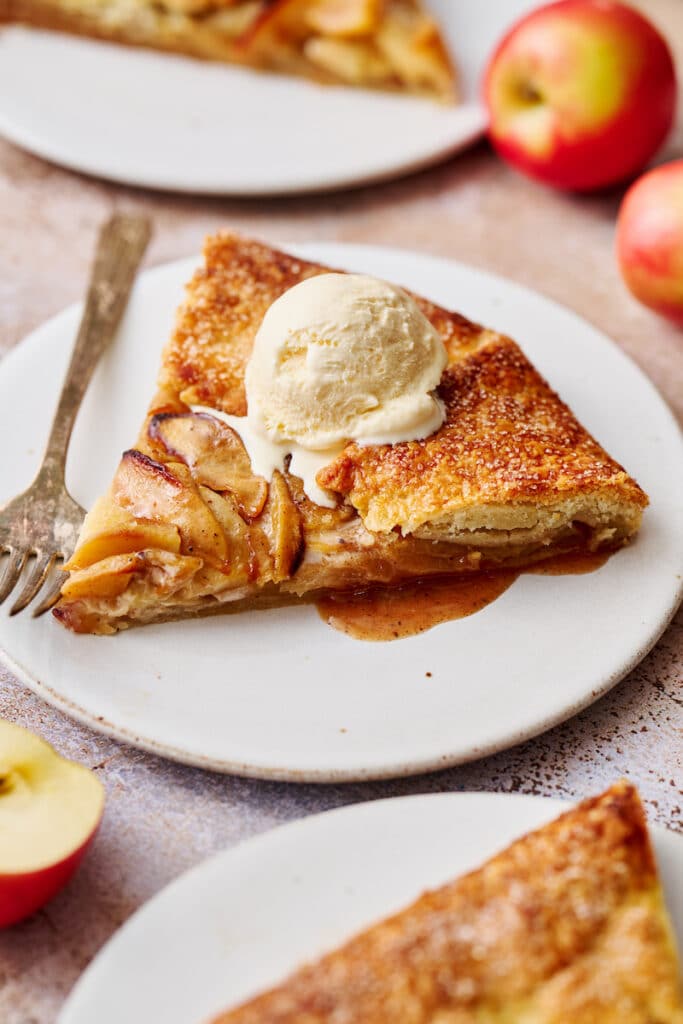 Slice of apple galette with vanilla ice cream on top.