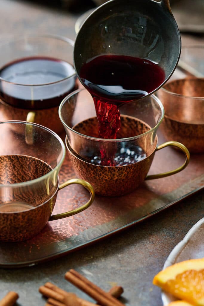 Mulled wine being poured into a glass.