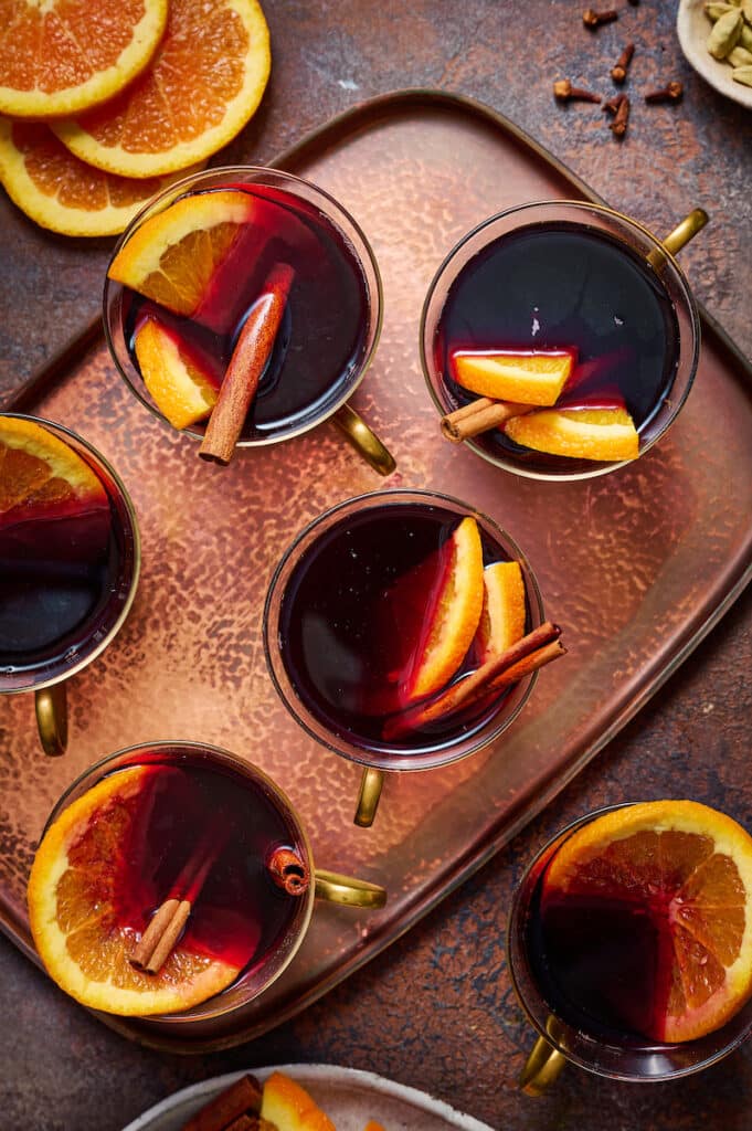 Mulled Wine in glasses with orange slices and cinnamon sticks.